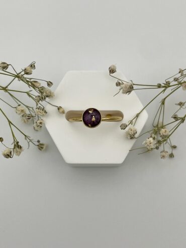 Anillo redondo con pétalos de flor morada oscura