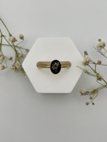 Anillo ovalado negro con florecitas naranjas