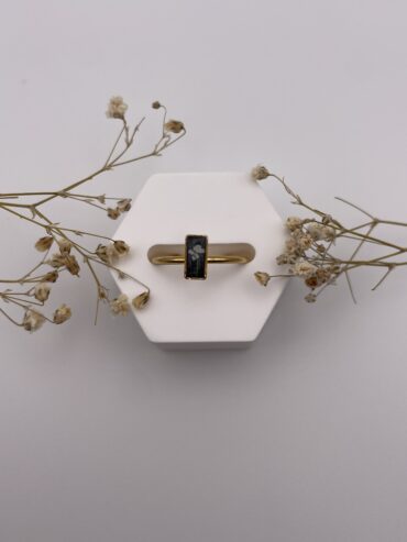 Anillo rectángulo negro con florecita blanca