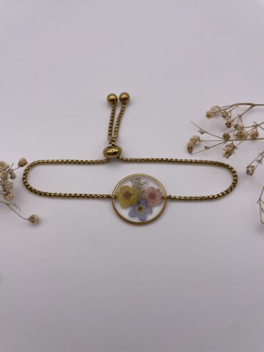 Pulsera redonda con flores amarilla, azul y rosa claro