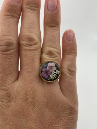 Anillo redondo negro con flores lila oscuro, rosa claro y blancas