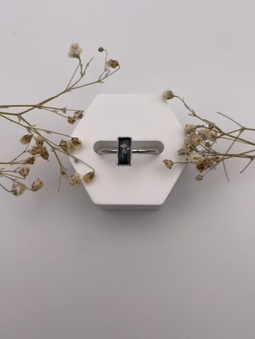 Anillo rectángulo negro con florecita blanca