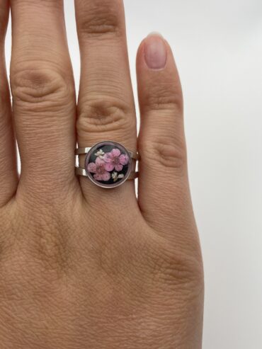Anillo redondo negro con flores rosas y blancas