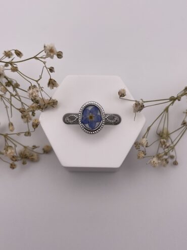 Anillo ovalado blanco con flor azul