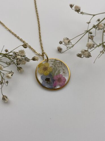 Collar redondo con flores amarilla, azul, rosa y hoja verde