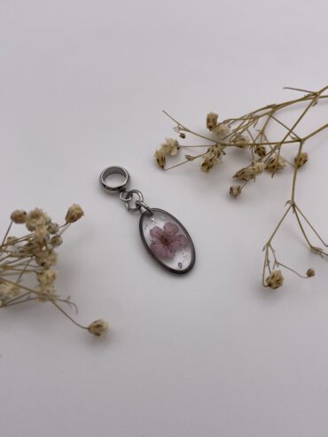 Charm ovalado con flor lila claro y pisquitos plateados