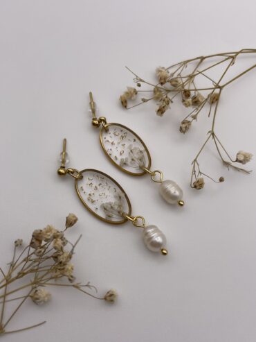 Pendientes ovalados con florecitas blancas, pisquitos dorados y perlas