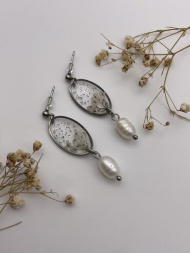 Pendientes ovalados con florecitas blancas, pisquitos plateados y perlas