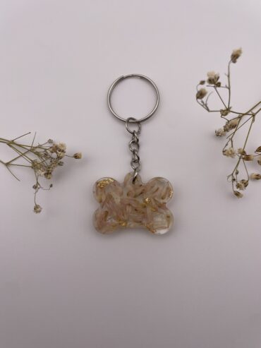 Llavero hueso con flores rosas y pisquitos dorados