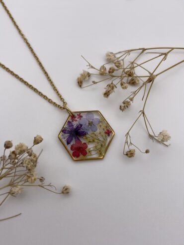 Collar hexágono con flores roja, azul y lila oscuro y florecitas amarillas y rojas